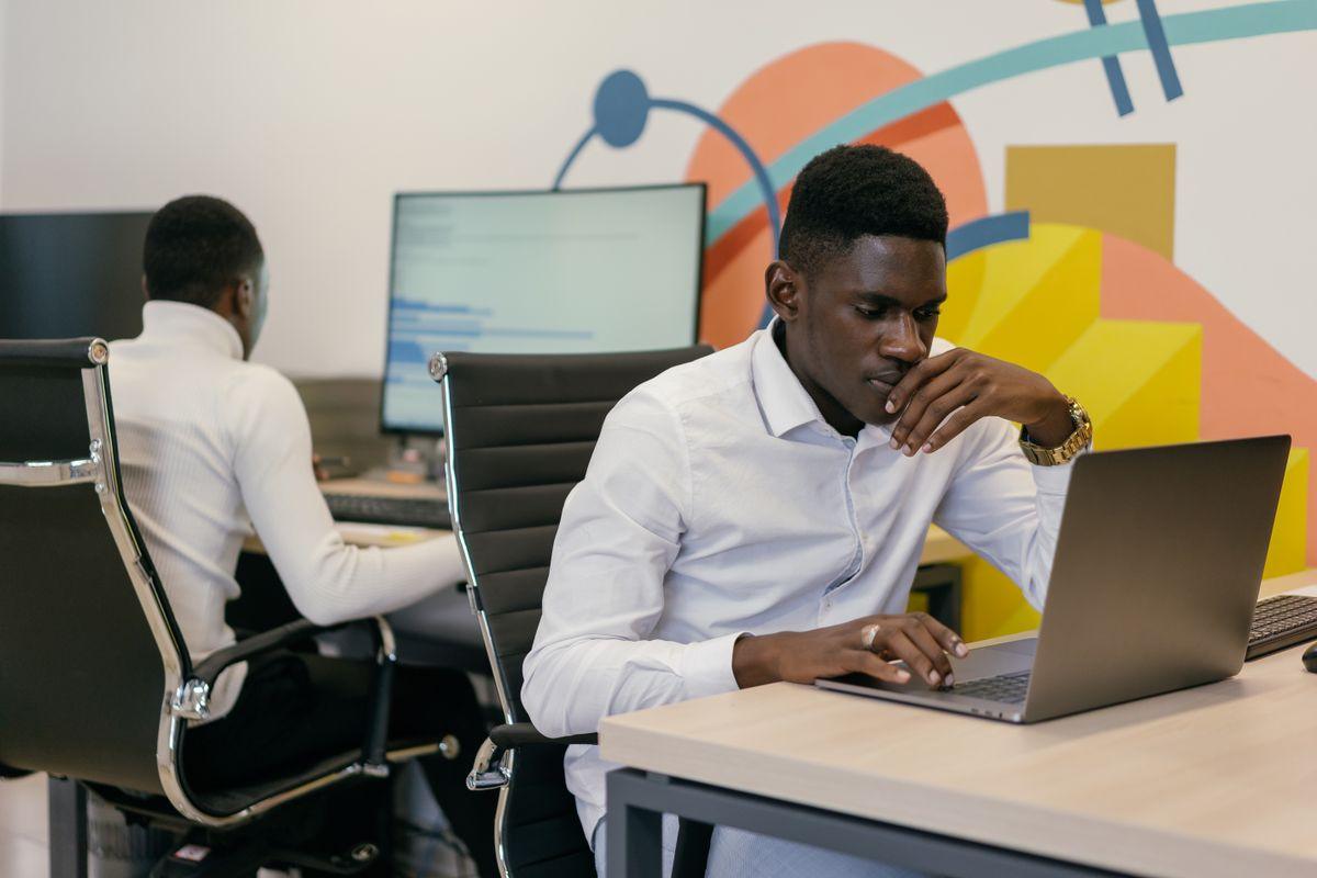 Deux informaticiens travaillent sur leurs écrans dans un open space